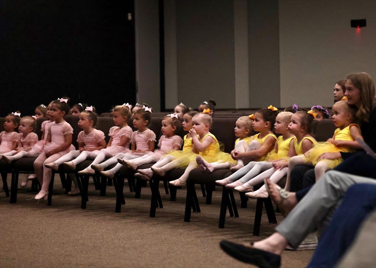 Dancers in their recital costumes seated in the front rows of the Sanctuary, waiting for their turn