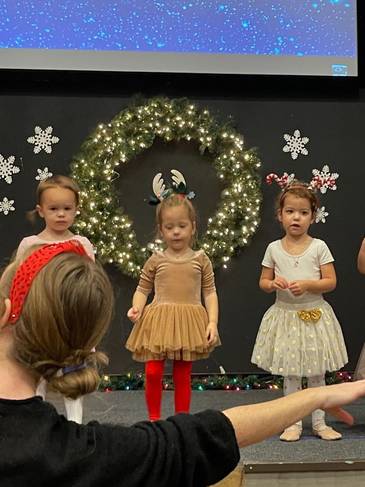 Dancers on stage at Watch Me Week, following their teacher through the Christmas dance